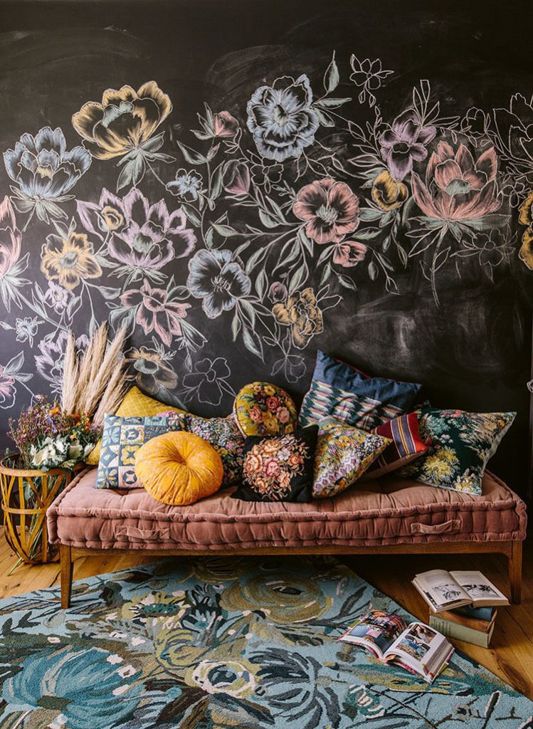 Bedroom with black wall and floral patterns and throw pillows