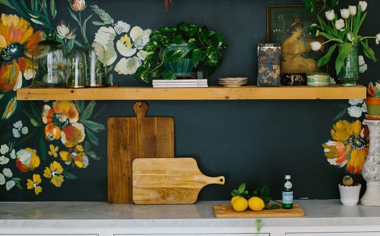 Kitchen with floral pattern on walls above open shelves