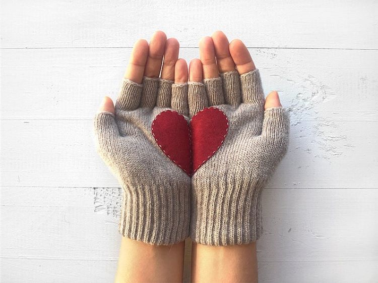Gray gloves, each with half a heart that make a full heart when the hands are laid together