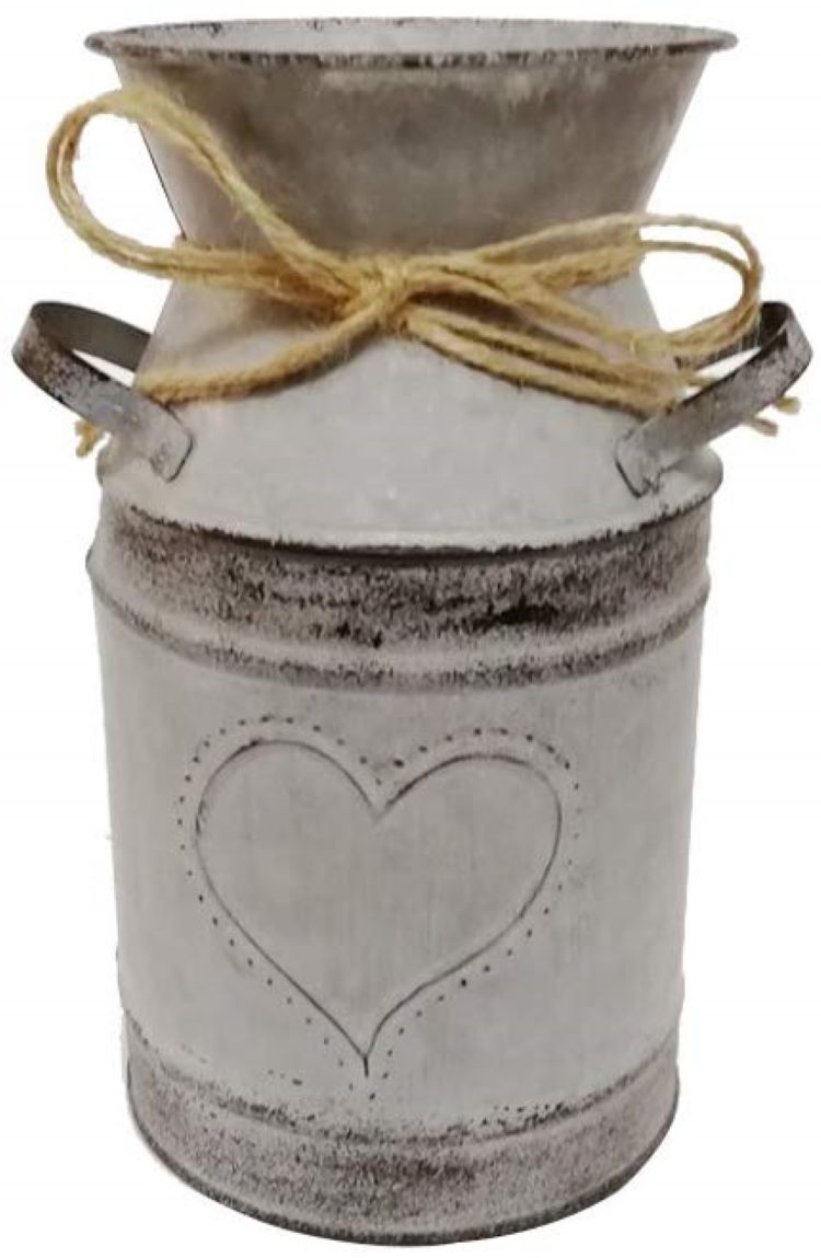 A white milk jug with a heart on the front and a ribbon tied around the spout