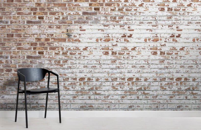 Exposed brick wallpaper with chair in front