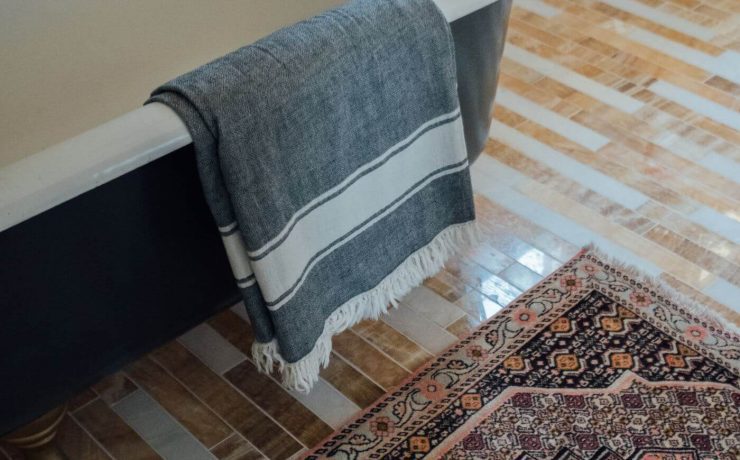 vintage Persian rug next to a blue claw foot tub