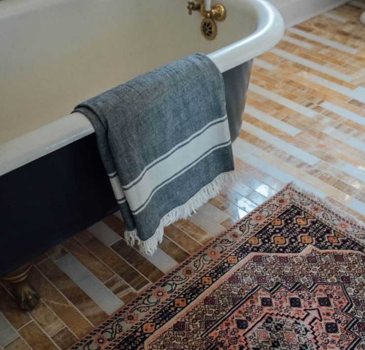 vintage Persian rug next to a blue claw foot tub