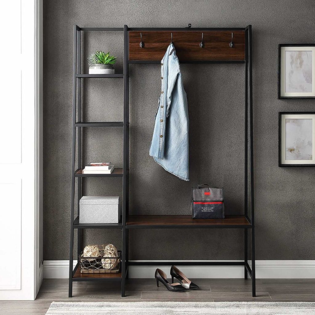 Set of metal shelves with bench and wall hooks against gray wall