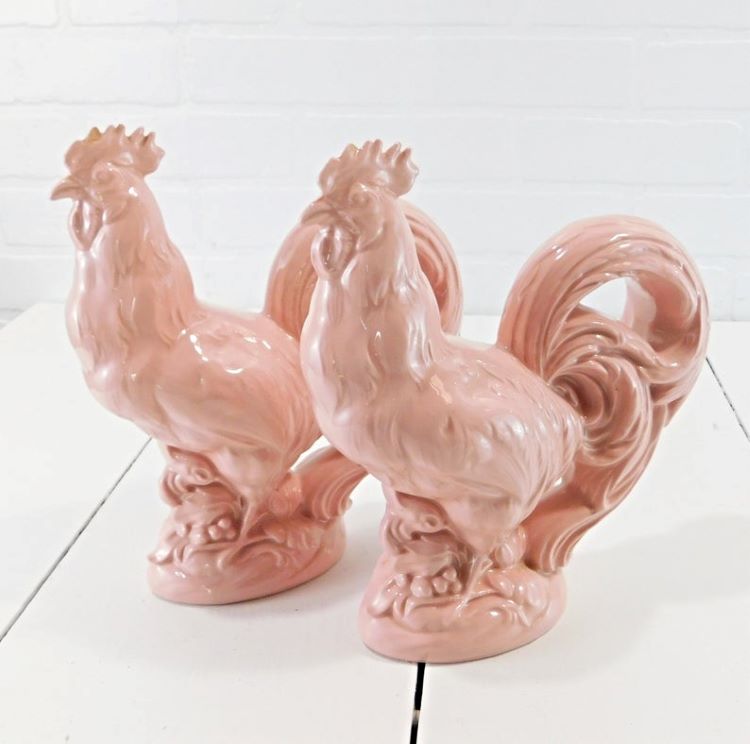 Two large rooster figurines in baby pink