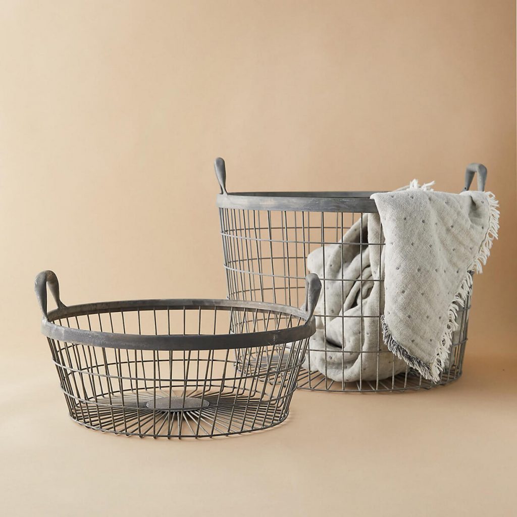 Two metal baskets, one with a blanket inside