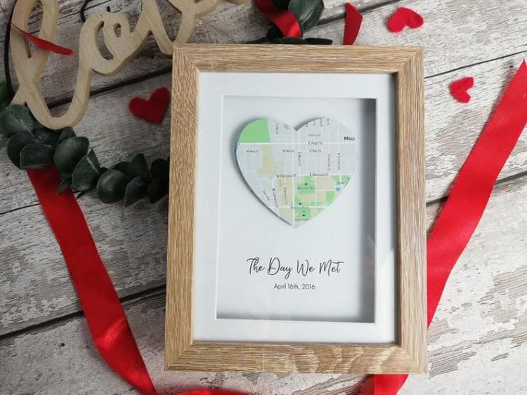A map cut into a heart and framed with the words, "the day we met"