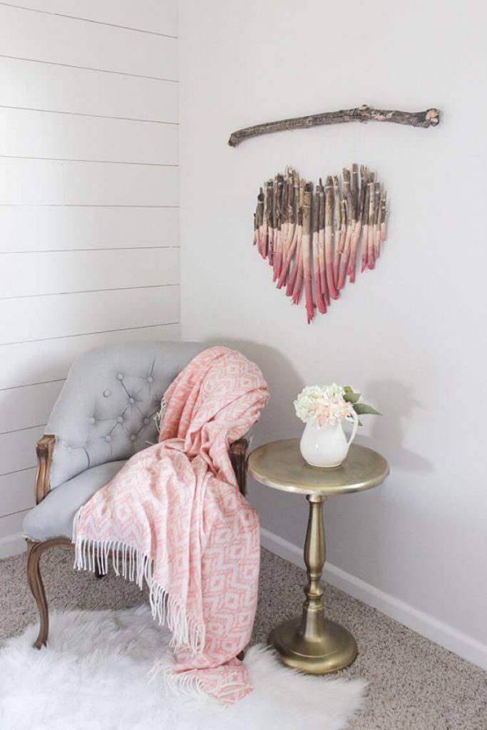 Rows of wood twigs painted in differing shades of pink combine to form a wood art piece shaped like a heart. Great piece for Valentine's day decor