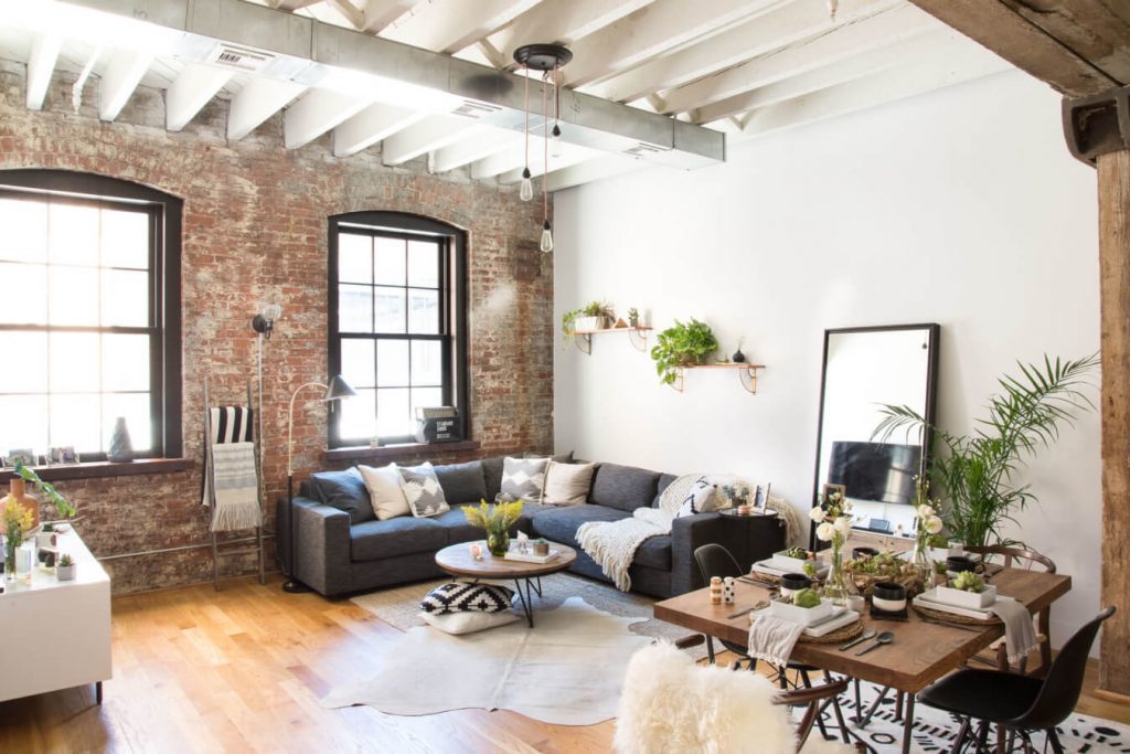 Live room with exposed ceiling beams and exposed brick