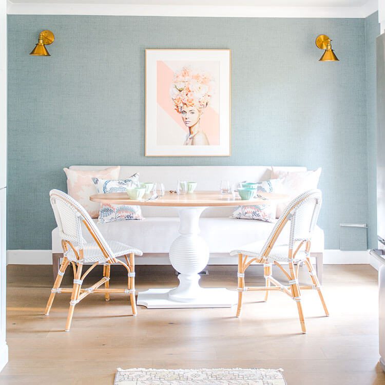 Dining room in pink and blue with modern accents and a round tulip table