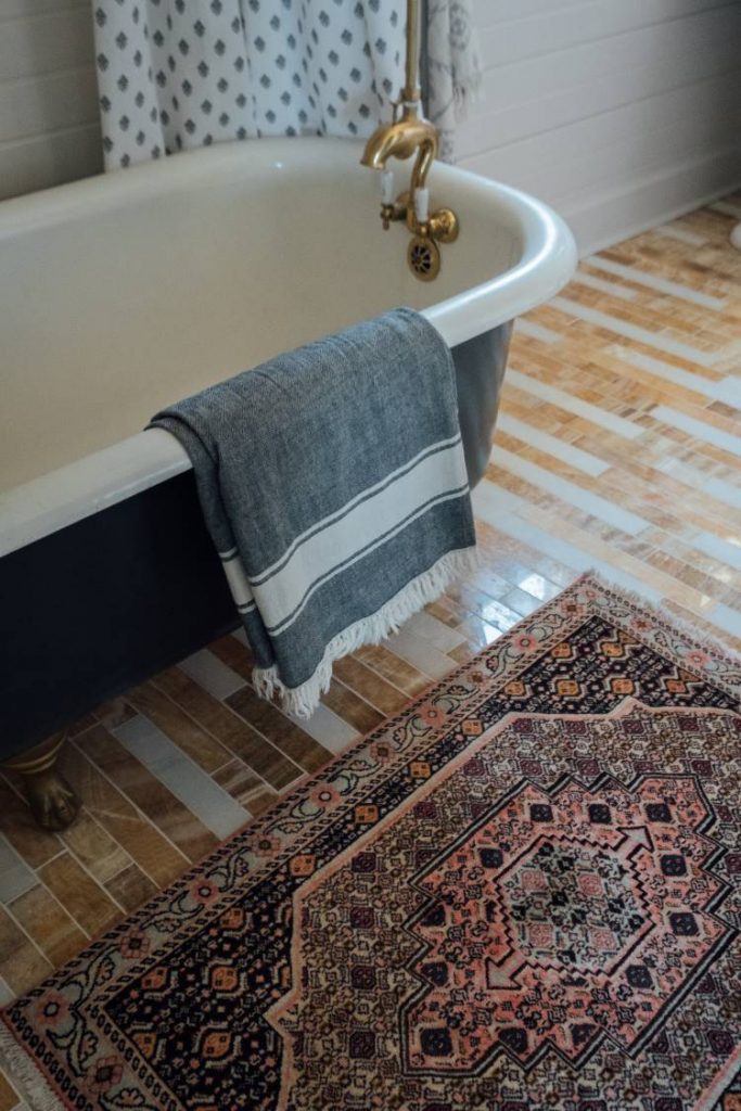 vintage Persian rug next to a blue claw foot tub