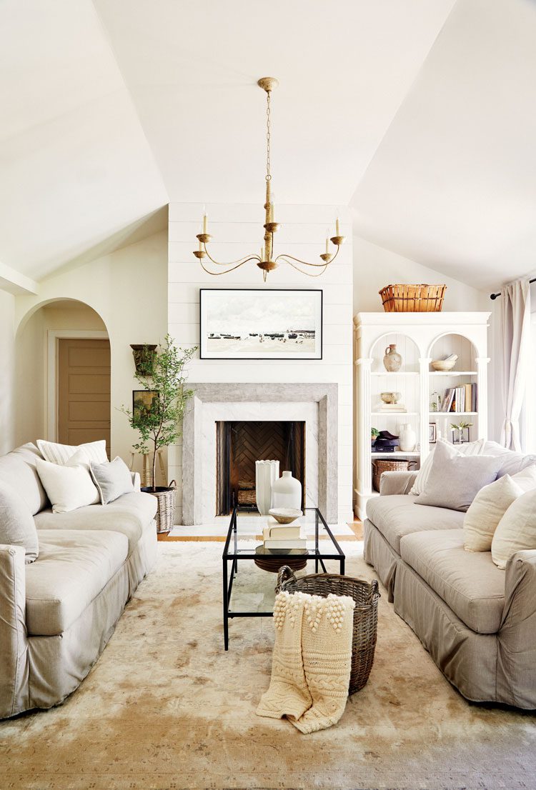 In the living room, Deb paired a white base with gray accents in the sofas, fireplace surround and area rug.