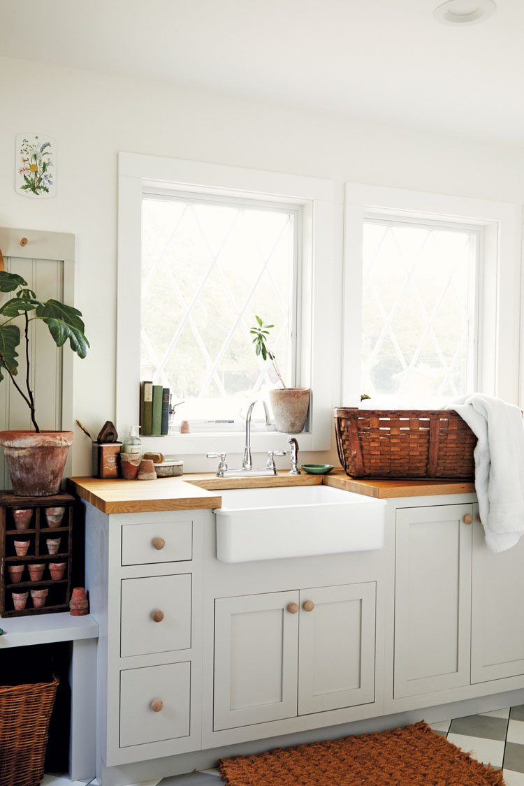 White cabinets under butcher block countertops. The cabinet doorknobs are made of wood to complement the butcherblock counters. 