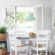Farmhouse kitchen with white table and chairs and turquoise pendant lighting to refresh a room