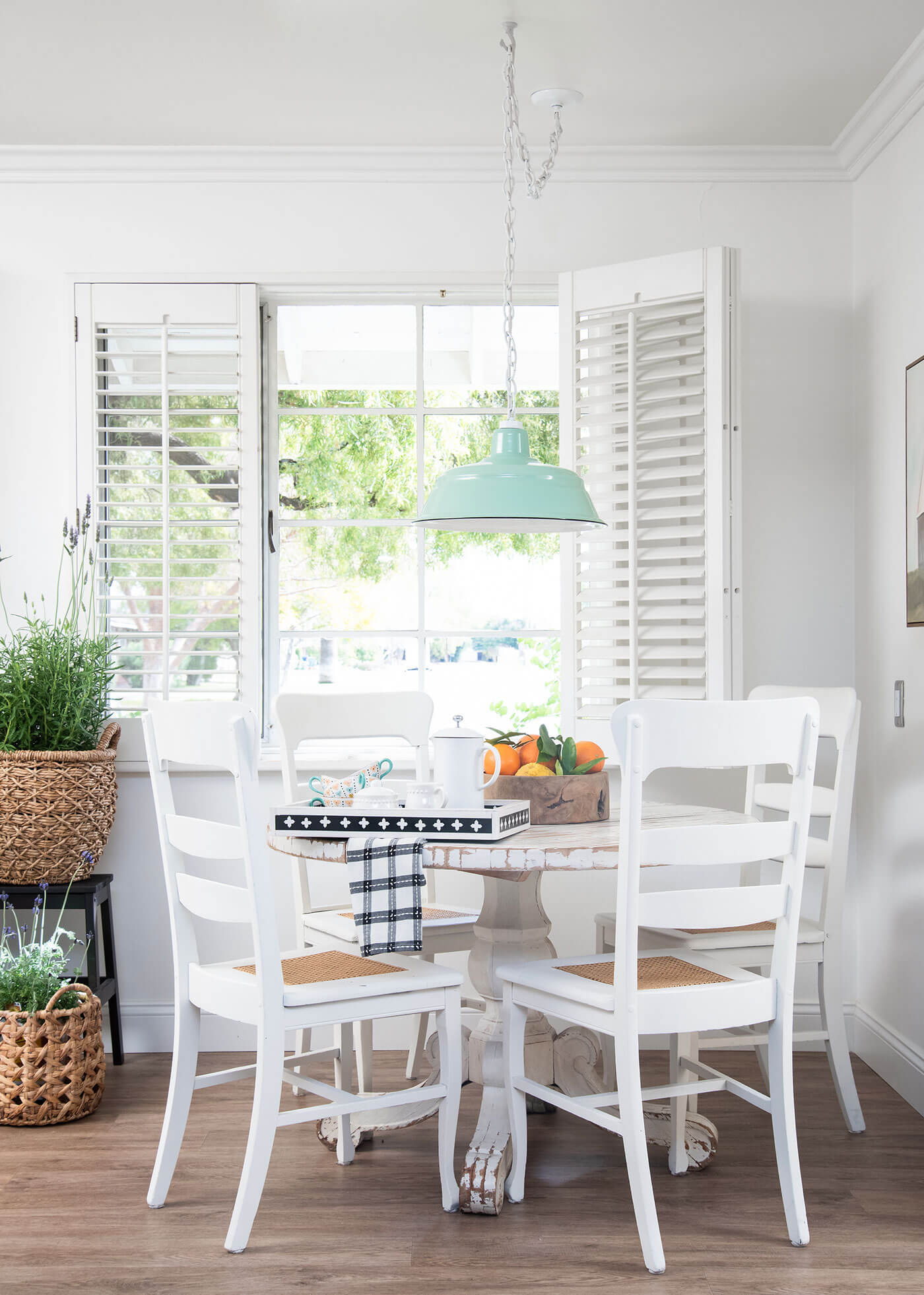 Farmhouse kitchen with white table and chairs and turquoise pendant lighting to refresh a room