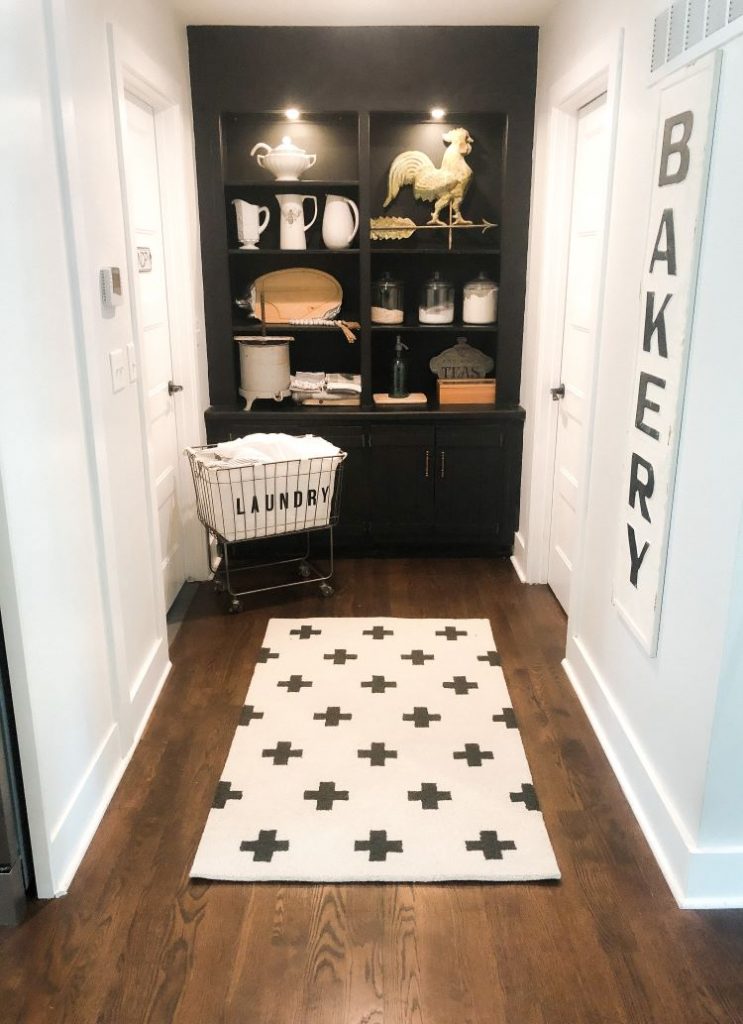 Black built-in shelves are against the wall and richly dark wood floors