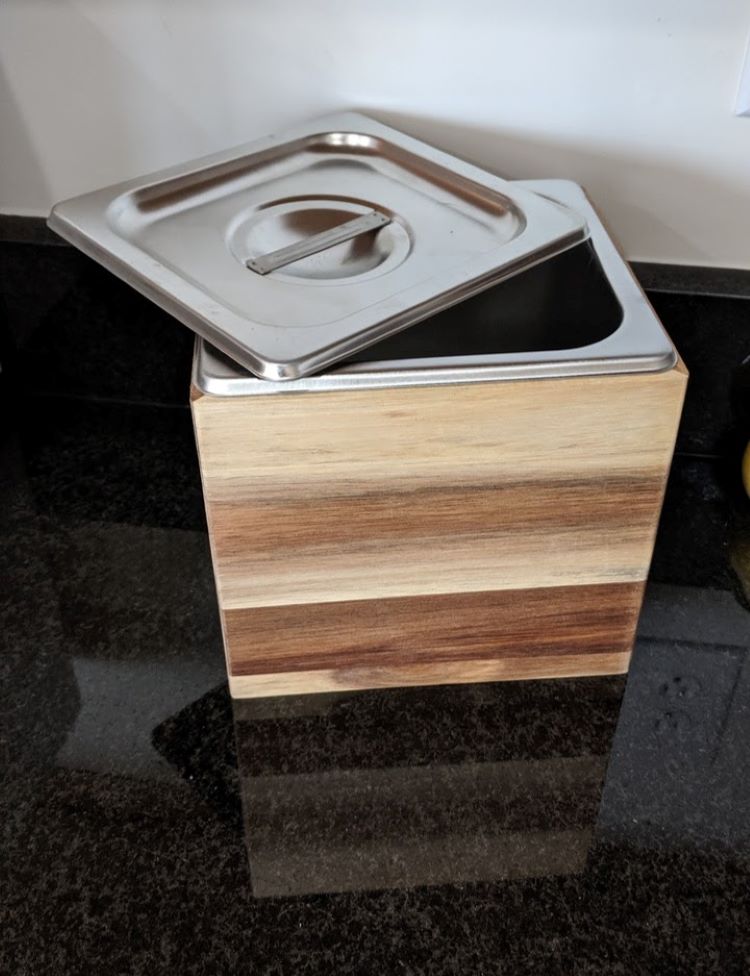 A countertop cospost bin on a black countertop