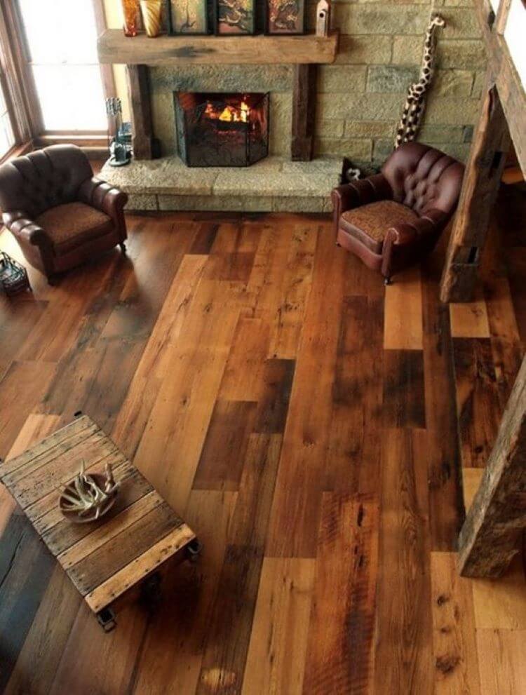 warm, rustic flooring in front of a stone fireplace