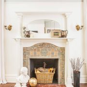 Wood floor around a white fireplace and antique tile