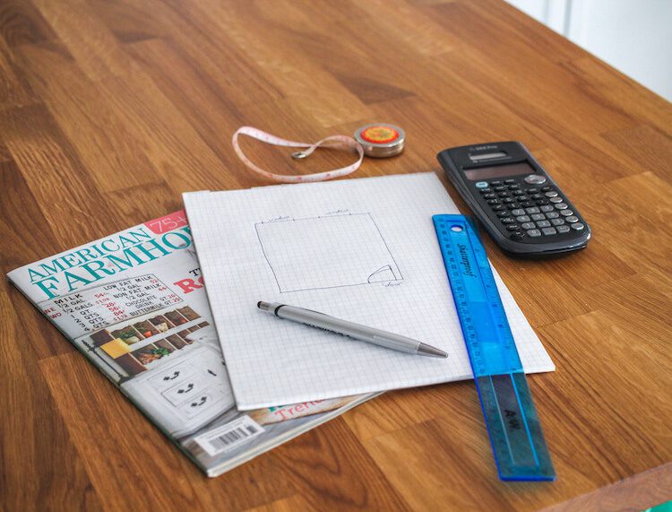 Countertop with graph paper and drawing and calculating tools for diy room layout