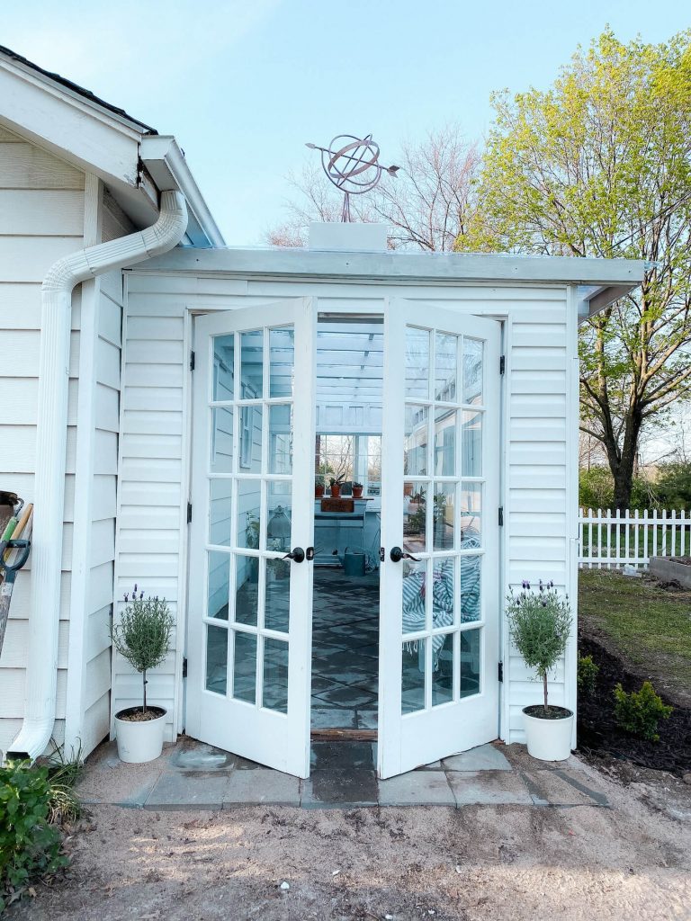 Open French doors leading into greenhouse garden