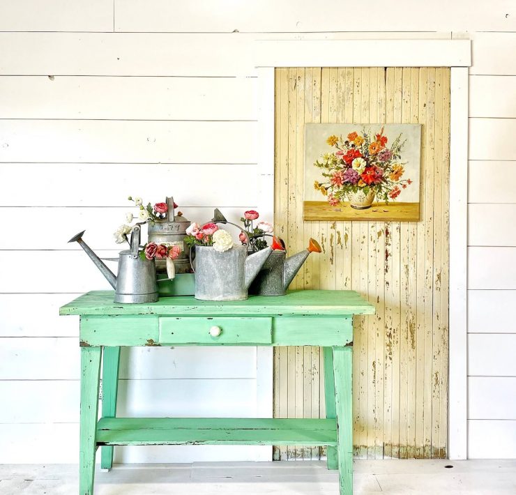 Turquoise side table in front of shiplap wall