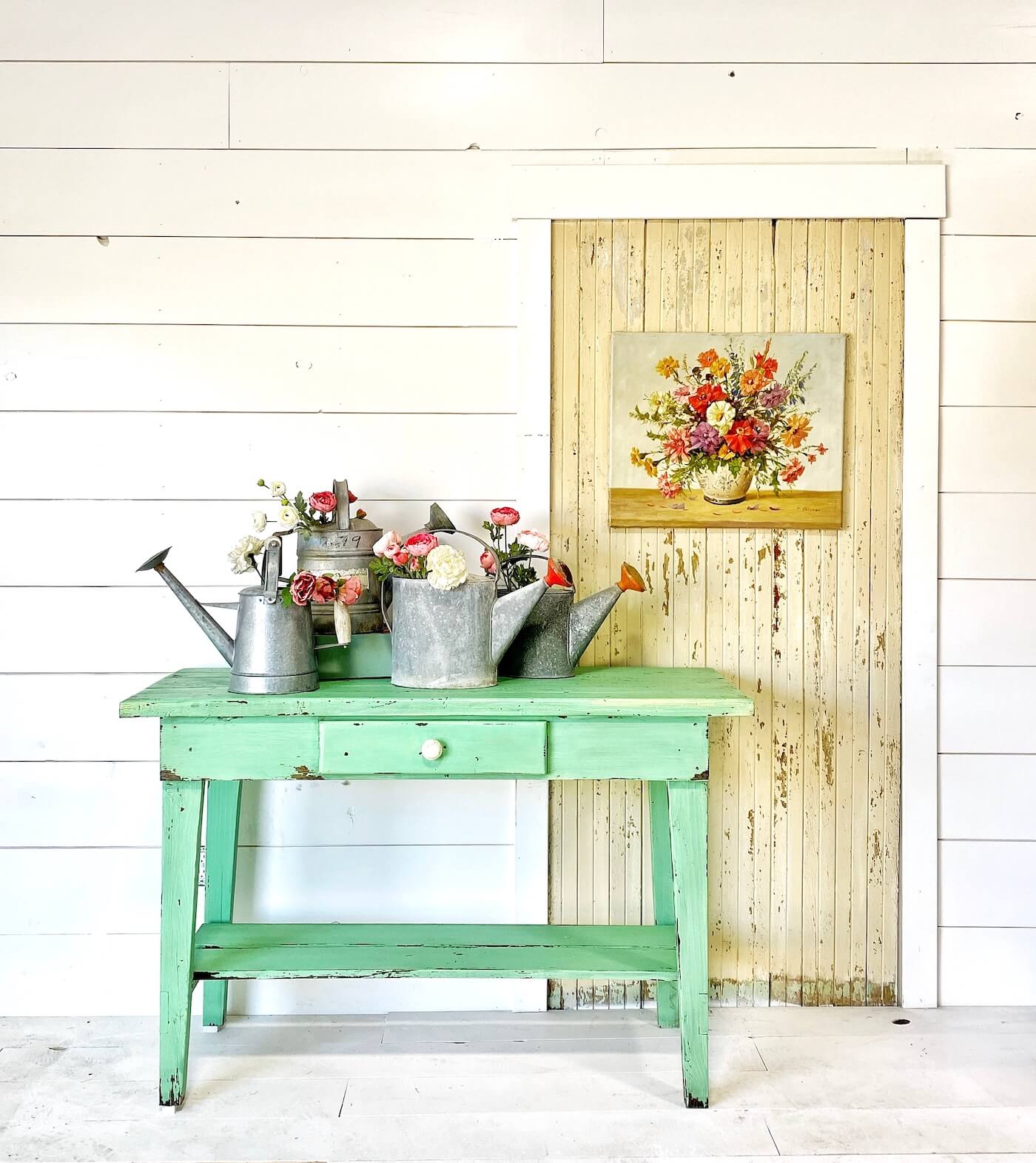 Turquoise side table in front of shiplap wall