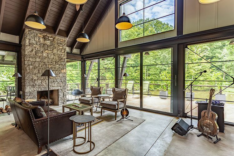 Living room with tall ceilings, windows and wood paneling