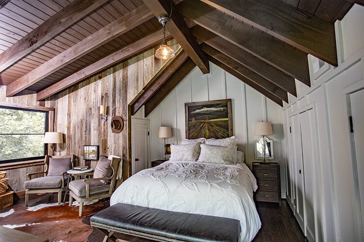 Bedroom with high roofline and wood paneling