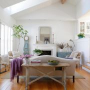 White living room with neutral furniture, purple blanket and vintage finds
