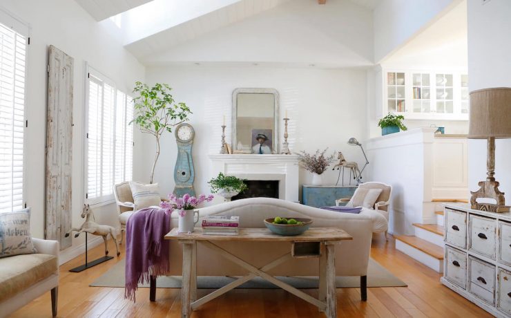 White living room with neutral furniture, purple blanket and vintage finds