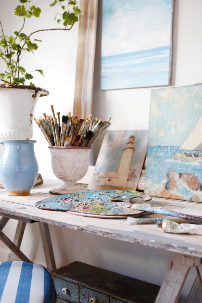 Art table with palette, paint brushes and artwork for flea market shopping tips