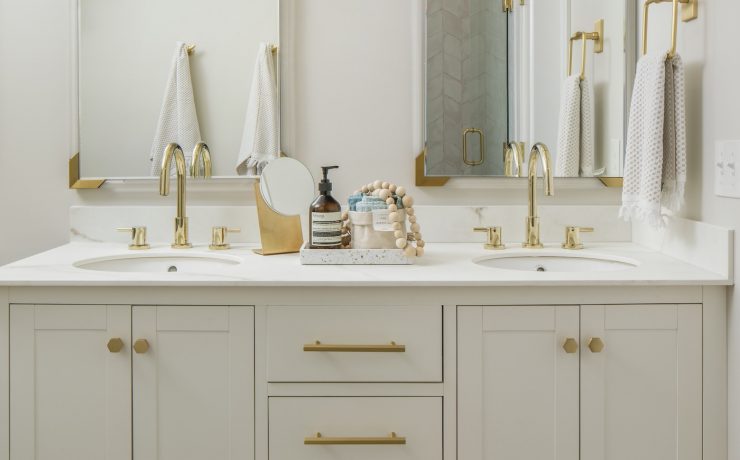 White farmhouse bathroom with white vanity and gold finishes