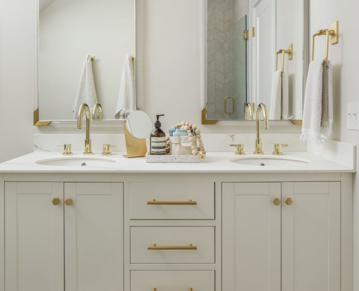 White farmhouse bathroom with white vanity and gold finishes