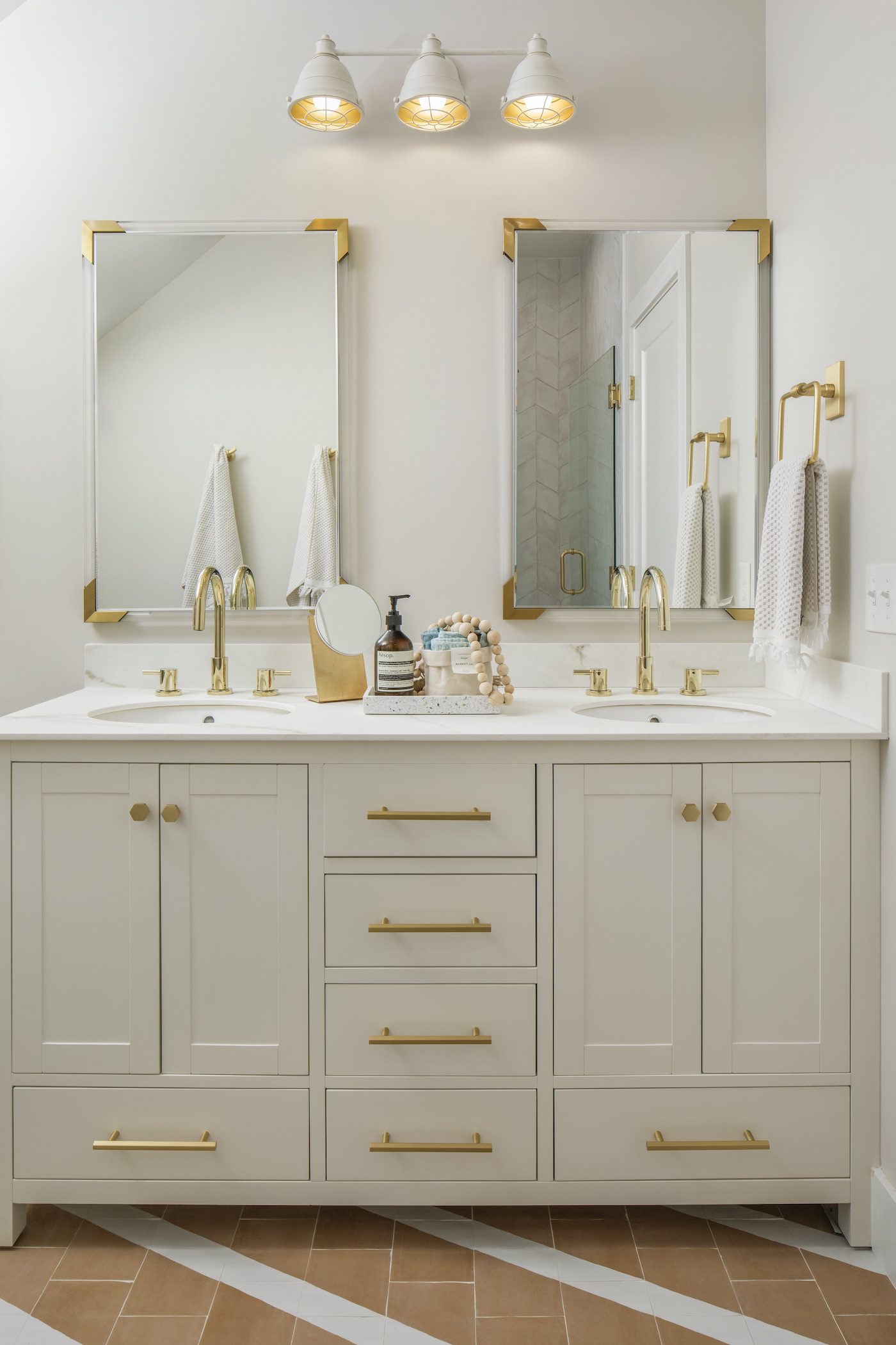 White farmhouse bathroom with white vanity and gold finishes