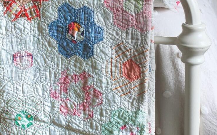 Vintage quilt on back of bed