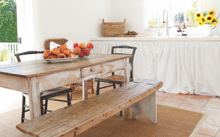 White open farmhouse kitchen with rustic wood table and sunflowers