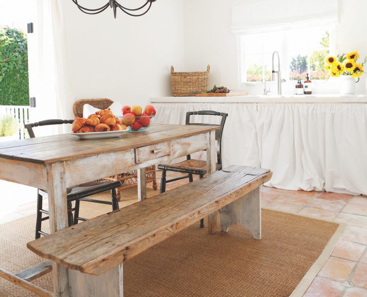 White open farmhouse kitchen with rustic wood table and sunflowers