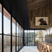 Dining room in modern barn home with wall to wall windows and wood paneling