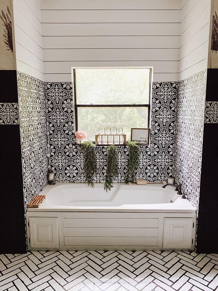 Farmhouse bathroom with shiplap and patterend tile above bathtub