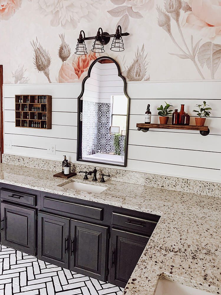 Sink area of farmhouse bathroom with mirror, floral wallpaper and shiplap