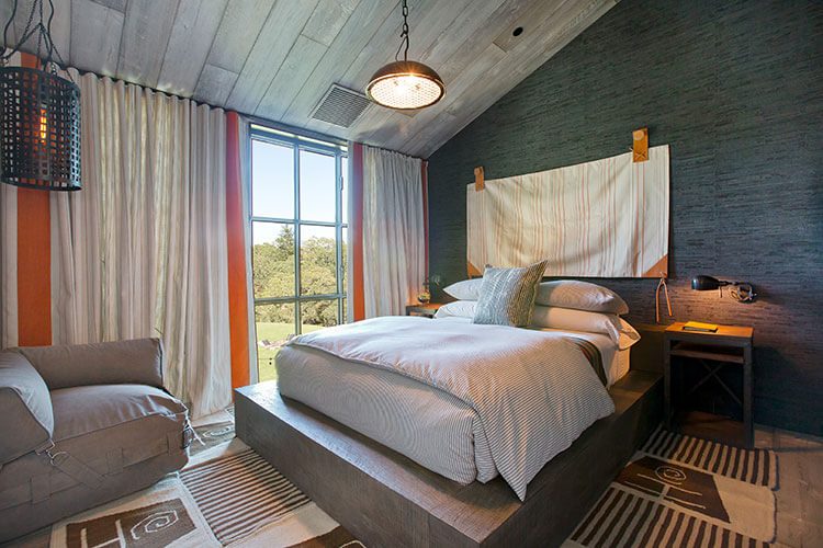 Bedroom with hanging linens, dark walls and wood paneling on the ceiling