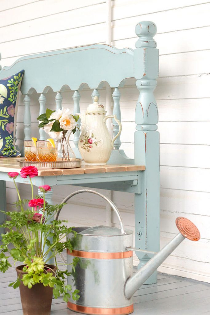 corner of bench outdoors with watering can for farmhouse in progrees