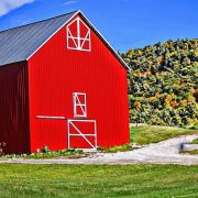 red barn with green hills in the background