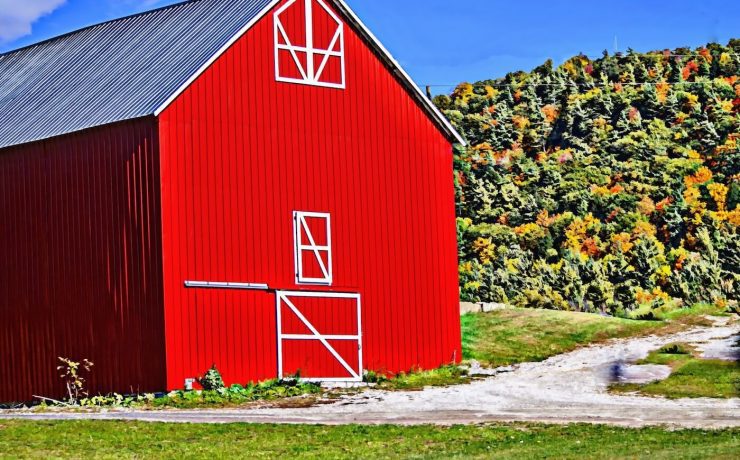 red barn with green hills in the background