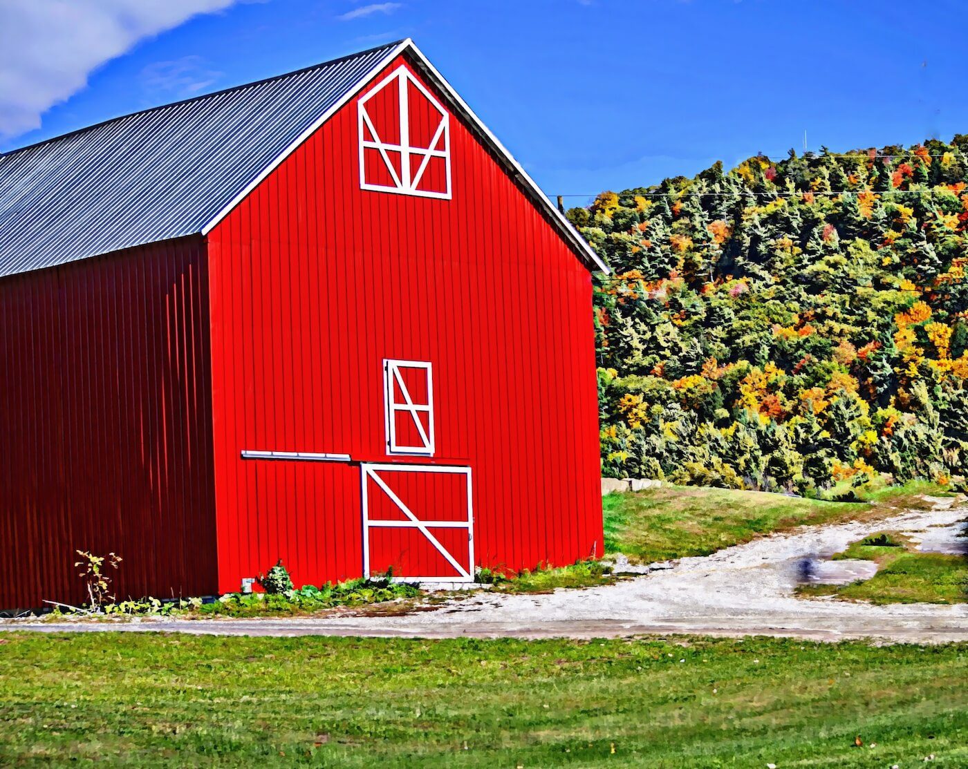 red barn with green hills in the background