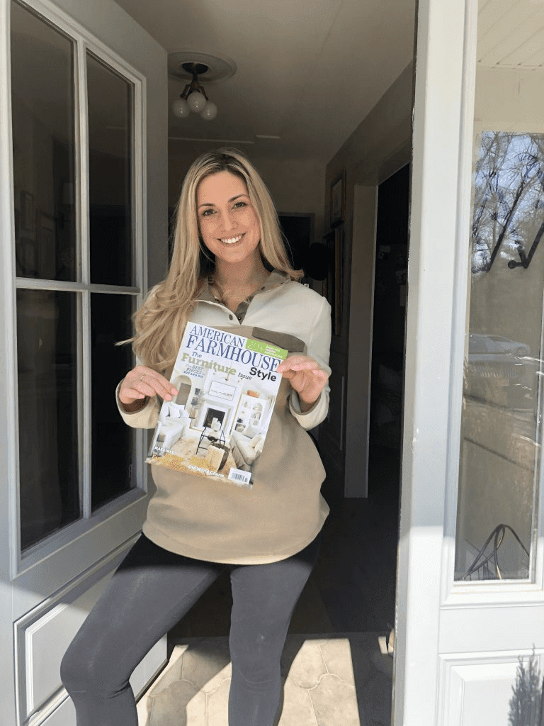 Deb Foglia standing with American Farmhouse Style magazine