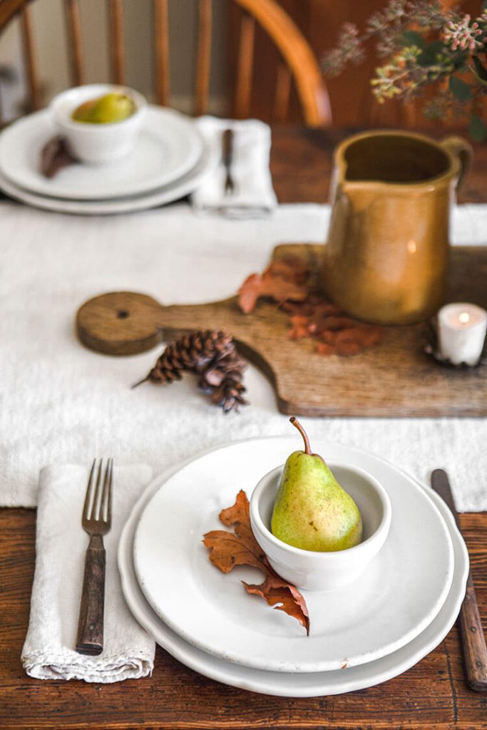 Table setting for fall tablescape with pear and autumn leaf