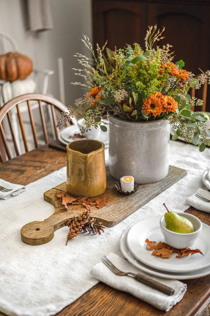 Centerpiece with wood cutting board and other rustic fall touches
