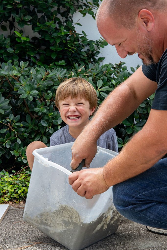 Little boy helping to mix concrete